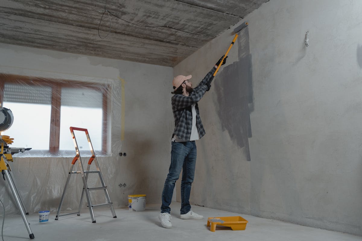Painter rolling fresh paint onto an interior wall